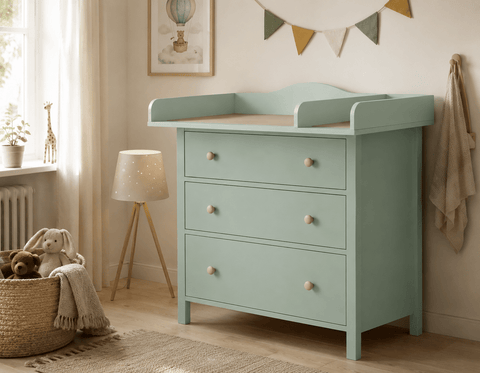 Ein KraftKids Wickelaufsatz XXL in Pastellgrün, extra breit mit 108 cm und Trennwand, passt in ein 108 cm HEMNES und steht in einem gemütlichen Kinderzimmer mit drei Schubladen, Kuscheltieren, Korb, Lampe, Fenster und Deko-Girlande.