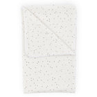 Eine gefaltete KraftKids Babydecke Musselin mit goldenen Punkten auf Weiß liegt vor einem schlichten weißen Hintergrund.