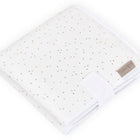 Die KraftKids Reisewickelunterlage Musselin mit goldenen Punkten auf Weiß ist kompakt gefaltet mit braunem Label - perfekt als platzsparende Wickelauflage für unterwegs oder praktische Reiseauflage.