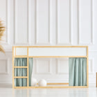 Ein minimalistisches Kinderzimmer mit einem IKEA Kura Hochbett mit KraftKids Hochbettvorhänge Set 2+1 Musselin mint, dekorativen Gräsern in einer geflochtenen Vase und zwei Holzhockern, die das helle, weiße Zimmer vervollständigen.