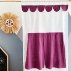 Das KraftKids Puppentheater Kasperletheater Musselin purpur inkl.. Die Teleskopstange, ein handgefertigter weißer Vorhang mit lila Details, hängt vor einer geometrischen Wand - ideal für Puppenspiele. Auf der linken Seite befinden sich ein Strohlöwengesicht und eine "ZOE"-Tafel.